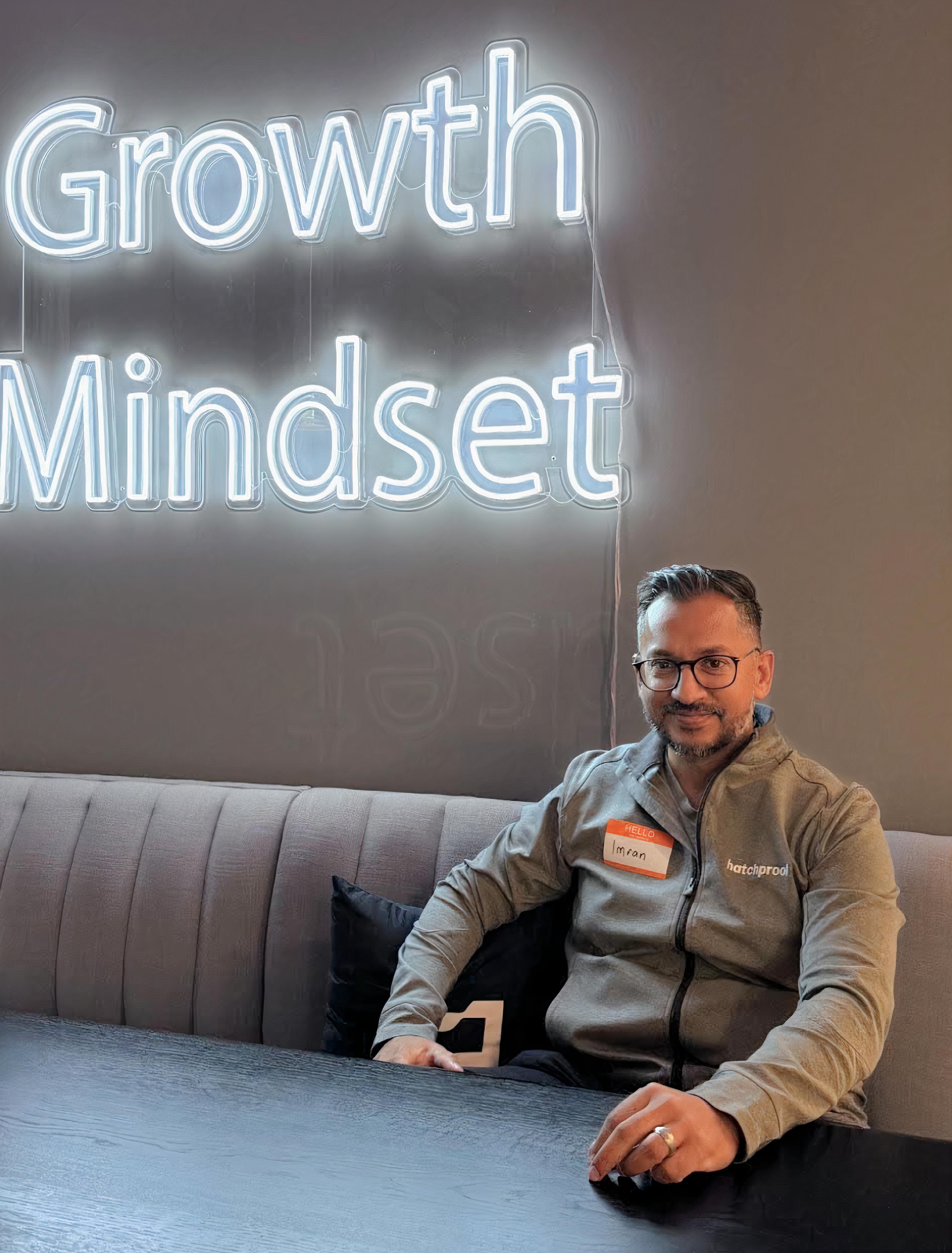 Photo of a man in front of a sign that says "Growth Mindset"